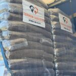 Stapel von großen, durchsichtigen Plastiktüten, gefüllt mit Tierfutter, beschriftet mit Tierheim Tierfutter mit Herz- und Tiermotiven. Die Säcke sind auf einen Lastwagen geladen, bereit zur Spende oder Auslieferung.