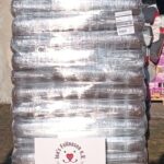 Ein großer Stapel eingeschweißter Tüten ist auf einer Palette vor einem Gebäude zu sehen. Davor steht ein Schild mit einem Herz und einem Pfotenabdruck: Die Fellnasen sagen Danke. Ihr seid einfach großartig!.