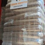 In einem Lkw steht eine große Palette, auf der Pakete mit Tierfutter gestapelt sind, die in Plastikfolie verpackt und mit der Aufschrift „Tierheim Tierfutter Spenden und Helfen“ sowie einem Herz- und Tierlogo versehen sind.