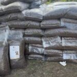 Ein großer Stapel durchsichtiger Plastiktüten, gefüllt mit braunen Tierfutterpellets.