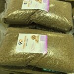 Ein Stapel in Plastikfolie verpackter Säcke mit Tierheim Tierfutter-Premium-Trockenfutter für Welpen auf einer Palette.