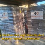 Drei mit Plastikfolie umwickelte Paletten mit Tierfutter, versehen mit Aufklebern mit der Aufschrift Tierheim Tierfutter Spenden und Helfen sowie einem darüberliegenden Text, in dem dem Spender gedankt wird.